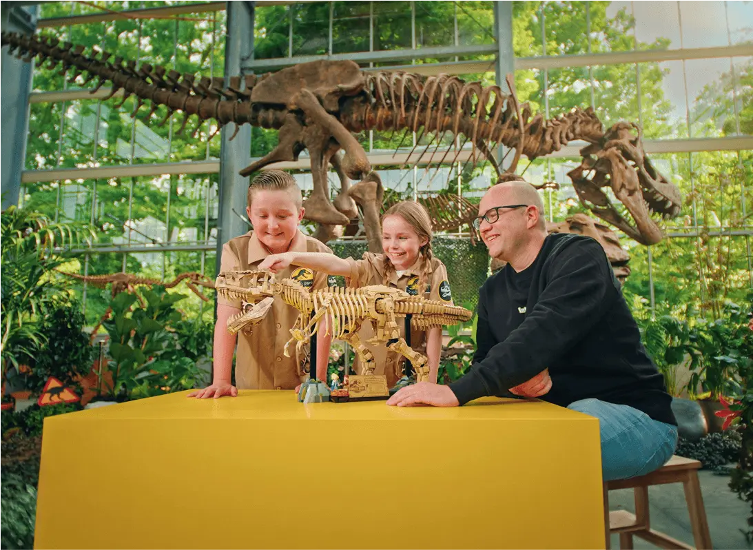 Twee kinderen met LEGO Expert Bob en een LEGO T. rex